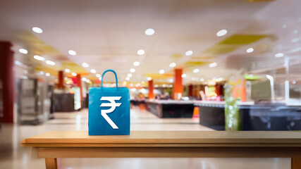 Fototapeta premium Shopping bag having Indian rupee symbol printed on it placed on a billing counter with retail shopping mall blurred ambience