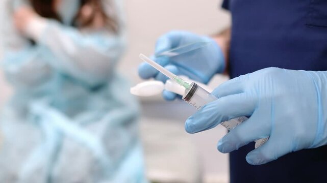 Mammalogist doctor is preparing to examine woman breasts and lymph nodes using ultrasound for diagnosis of breast cancer during appointment. Oncologist holding hands biopsy slide glasses and syringe.