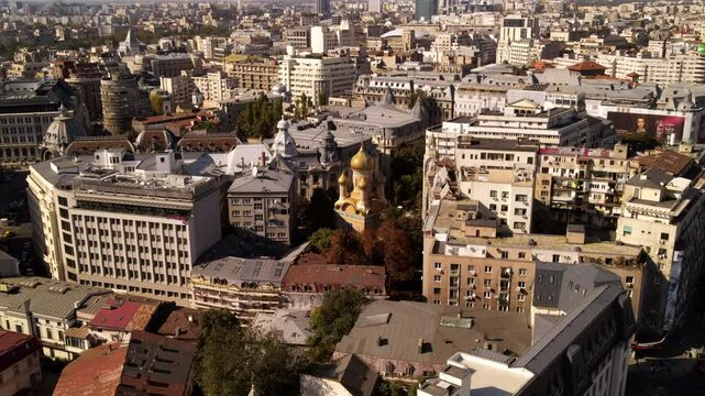 Aerial Panning Shot Of Golden Architectural Domes Of Famous Church In Residential City On Sunny Day - Bucharest, Romania