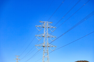 High Voltage Power Lines and Electricity Pylon Against Blue Sky