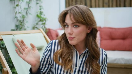 Pretty brunette drinking beverage talking to unknown friend at terrace closeup.