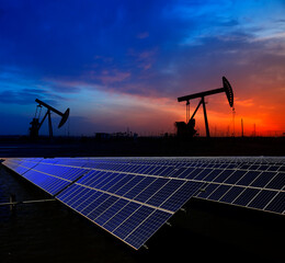 Oil pump with solar panels in the sunset
