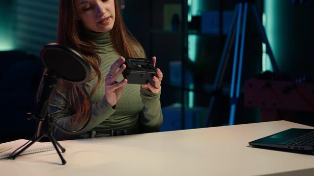 Tech expert holding V mount battery ensuring ample power to fuel production equipment, showing it to subscribers. Gen Z influencer vouching for professional charging device brand, camera A