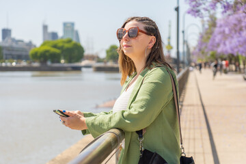 Woman enjoying the fresh air and view of the city harbor on a sunny day.