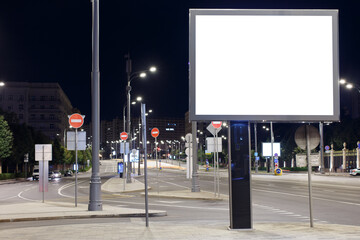 Large horizontal billboard in the night city. An empty road in a sleeping city. Mock-up.