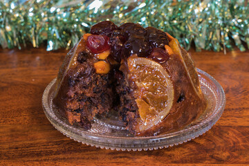 Traditional Festive Christmas Pudding, Fruit Cake on plate, look inside of the cake where is missing slice
