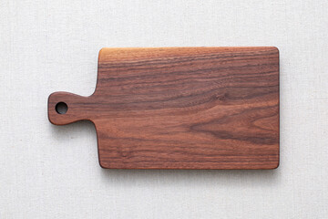Walnut handmade wood cutting board on the linen. wooden cutting board isolated