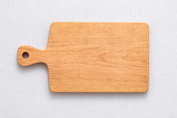 Cherry wood cutting board on linen. handmade wood cutting board. wooden cutting board