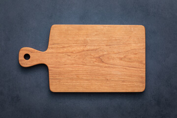 wooden cutting board isolated. Handmade cherry wood cutting board on cement table top.
