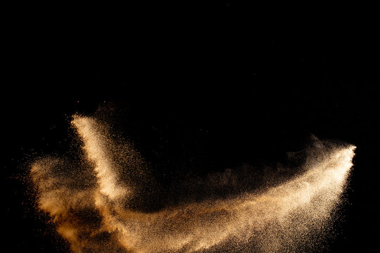 Sand flying explosion isolated on black background ,throwing freeze stop motion object design.
