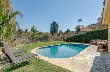 the backyard with a pool and lawn, showcasing how well-maintained it is. The house in this area has white walls and windows, while other areas have green grass, trees, and concrete surfaces.