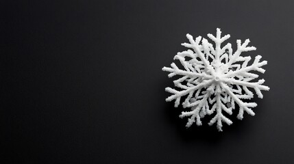 Lone snowflake resting on a smooth black surface, macro shot highlighting its delicate and intricate structure
