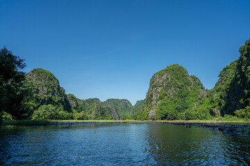山あいを流れる川に咲く蓮の花