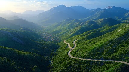 Mountain road winding through valley, sunset view.