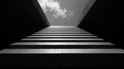 Monochrome stairs ascending to bright sky.
