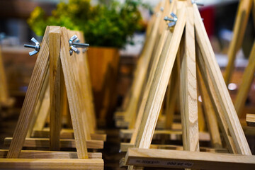 Small wooden easel in a store. A wooden easel frame for drawing paintings or other creations.