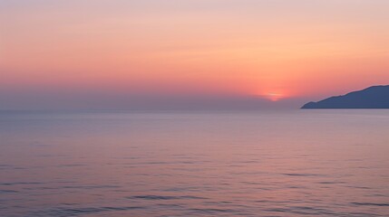 Naklejka premium Serene Sunset Over Calm Ocean and Distant Mountain