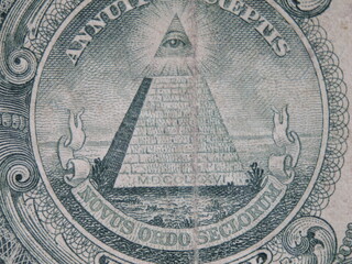 A close up of a US dollar bill with a pyramid and an eye on it