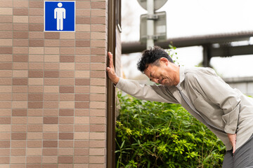 公衆トイレに入るミドル男性　ライフスタイルイメージ