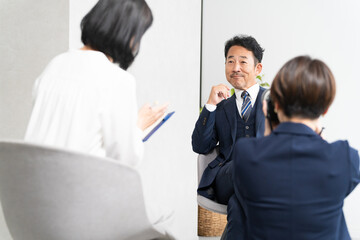 インタビューを受けるミドル男性　ビジネスイメージ