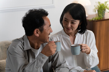 マグカップで飲み物を飲むミドル夫婦　ライフスタイルイメージ