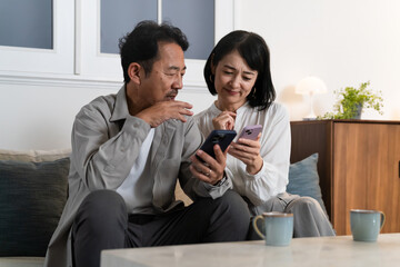 スマートフォンで調べものをするミドル夫婦　ライフスタイルイメージ