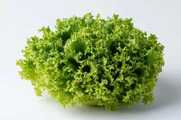 Obraz premium A fresh, vibrant green leafy lettuce rests on a clean white surface, showcasing its crisp texture and natural color.