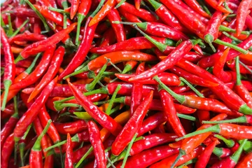 Selbstklebende Fototapeten Vibrant heap of ripe red chili peppers, essence of spicy cuisine, fiery flavor of Capsicum annuum. Closeup of fresh chilies essential gourmet cooking ingredient in any healthy kitchen. © KseniyA