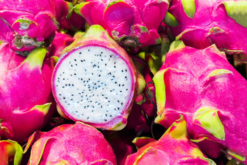 Vibrant ripe dragon fruits, also known as pitahaya or dragonfruit. Harvest of exotic pink and white...
