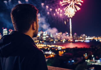 Obraz premium Man Watching Fireworks Over Cityscape at Night