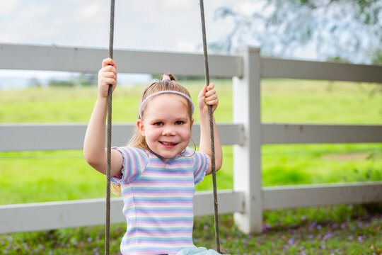 Six year old child swinging on swing in country with genetic condition lymphatic malformation