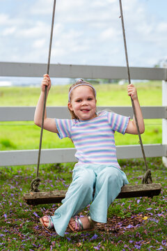 Six year old child swinging on swing in country with genetic condition lymphatic malformation