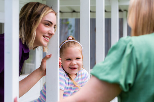 Speech therapist professional with girl interacting by cubby house talking and assessing child