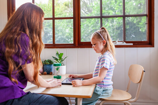Speech therapist professional with child using technology to help with language development