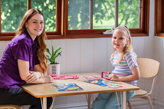 Child with speech disability looking at sound cards talking with speech-language pathologist
