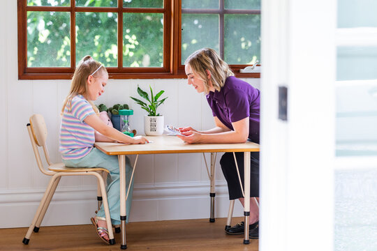 Child sitting at desk in speech pathology clinic using phonics card resources