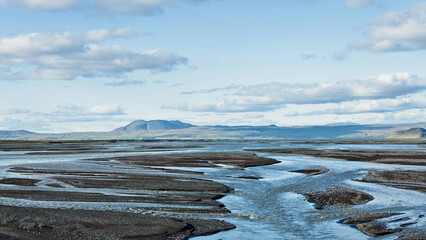 A river winding through the Icelandic landscape under a clear sky