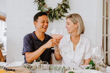Happy couple having celebratory toast during Christmas dinner.