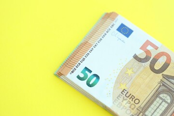 Big amount of one hundred and fifty euro money bills on yellow background