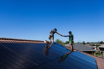 Tradesman electrician workers working together installing solar power bifacial panel system