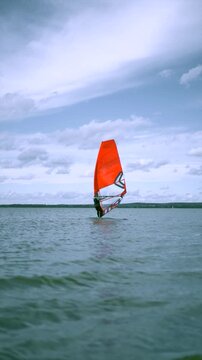 Man windsurfing in sea against blue sky