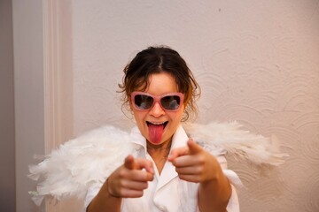 Young woman in white outfit with feathered wings and sunglasses