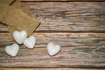 Marble stones in the shape of heart and cloth on wooden table