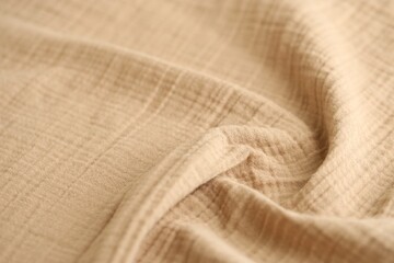 Texture of crumpled linen fabric under natural light in peach fuzz color