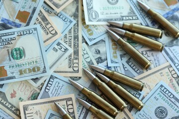 Yellow cartridges and bullets on dollar bills