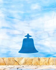 Bell Shadow on Blue Wall with Textured Surface and Stone Base