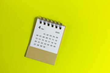 Monthly calendar for April 2025 on a yellow background.