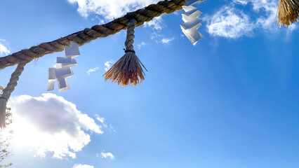 青空に光り指す神社のしめ縄と紙垂