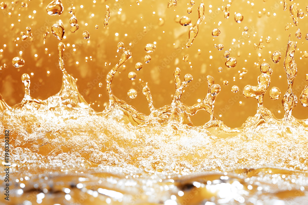 Poster The image captures vibrant water droplets splashing in a golden hue, creating a dynamic and mesmerizing effect