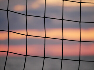 detail of a beachvolley ball net in a colorful cloudy sunset
